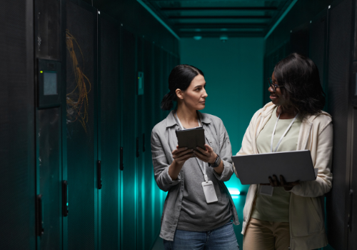 two women engineers consulting in a server room